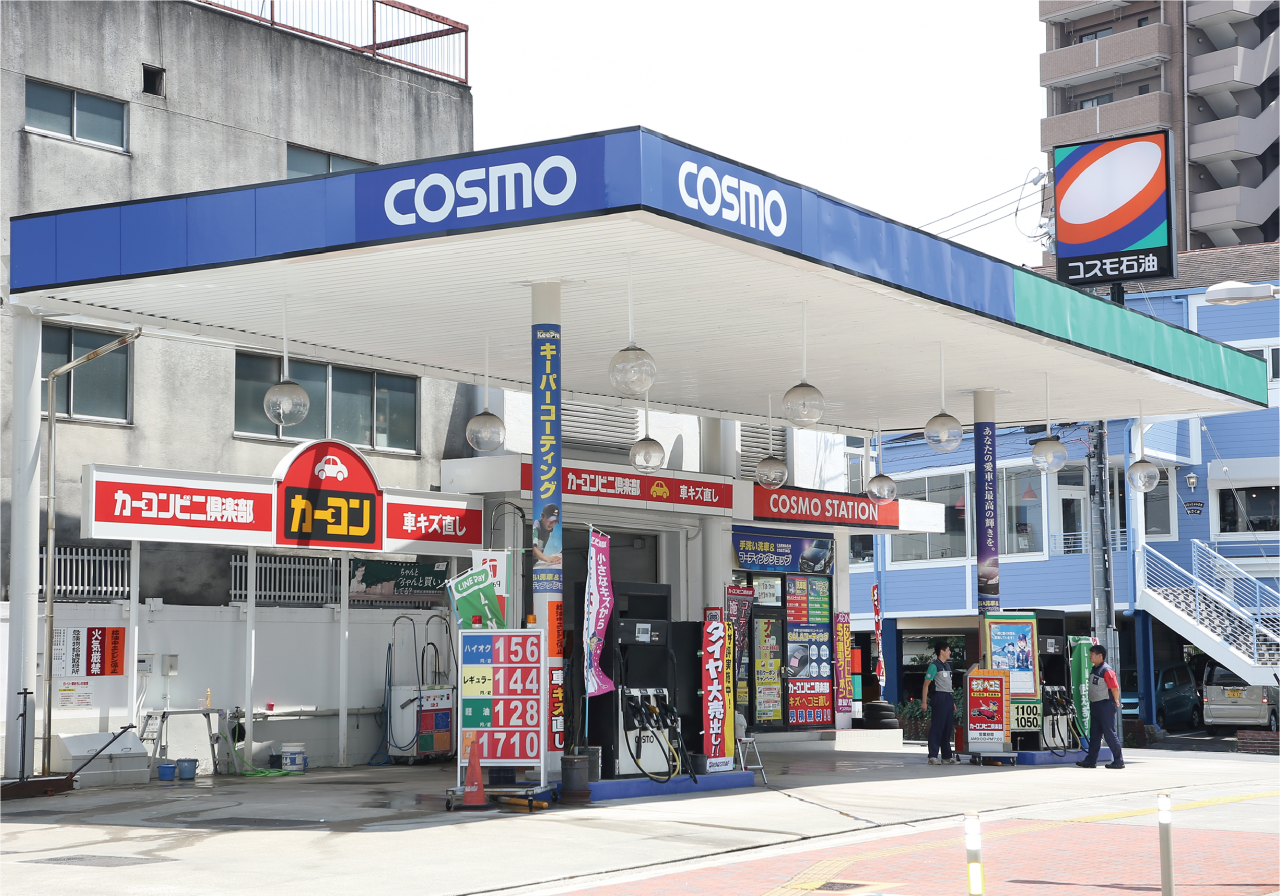 COSMO石油の青い看板とカーコンビニ俱楽部の赤い看板が目立つ八熊店の店構え。