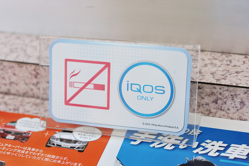 「iQOS ONLY」のサイン。電子タバコだけは店内で吸う事ができる。時代の流れに素早く対応